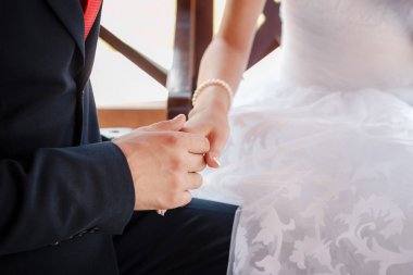 parkta bir bankta otururken el ele tutuşarak gençler