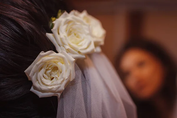 Λευκά τριαντάφυλλα στα μαλλιά της νύφης, στυλ για ένα γάμο — Φωτογραφία Αρχείου