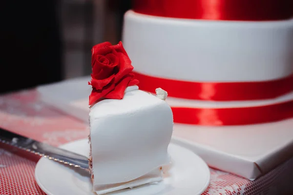 Gyönyörű fehér torta szalagokkal díszített, piros virágok, rózsák, és íj — Stock Fotó