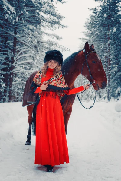 Foto Longitud completa de una hermosa chica y semental guapo, caballo en el invierno en la naturaleza —  Fotos de Stock