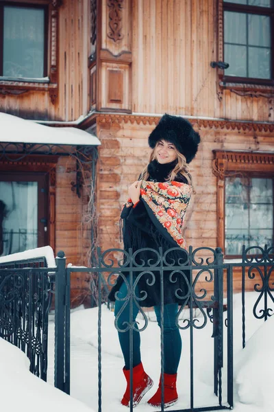 Portret van een mooi meisje in winter kleding, jas en hoed, verpakt in sjaal — Stockfoto