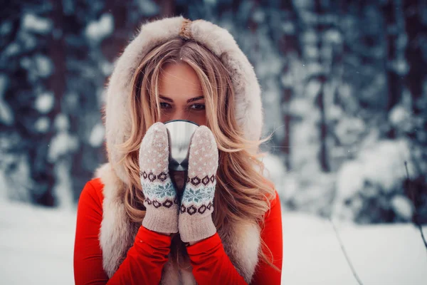 Bella ragazza sta bevendo una bevanda calda dalla tazza in inverno nella natura — Foto Stock