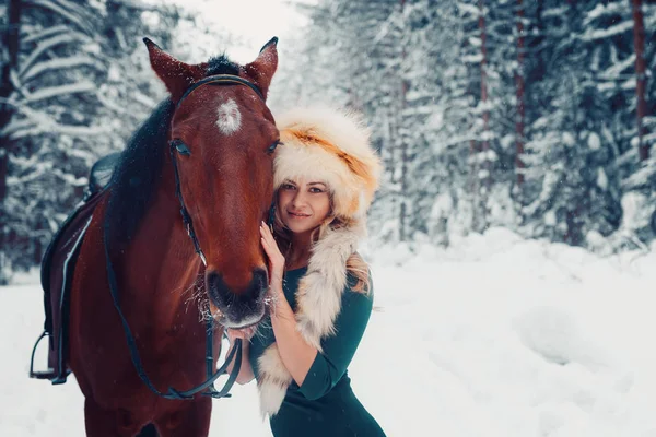 Portrait of a beautiful girl in  green dress,  cap from the fox, and  horse in the winter on the nature — Stock Photo, Image