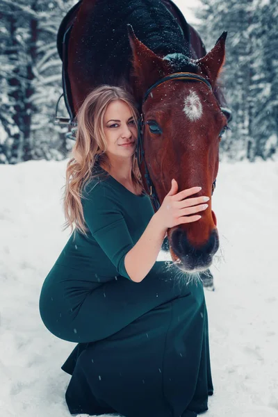 Photo Full-length of a beautiful girl in green dress, and horse in the winter on the nature — Stock Photo, Image