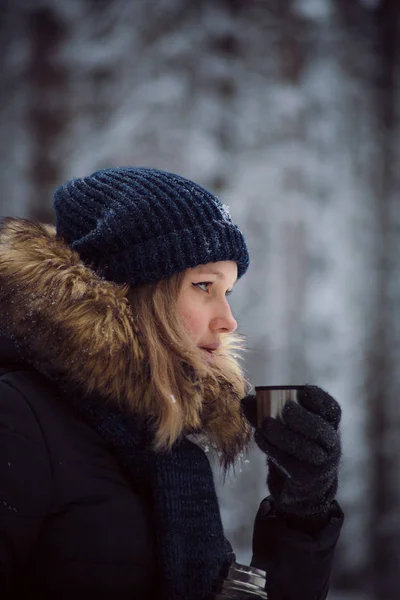 Девушка пьет горячий чай из термоса — стоковое фото