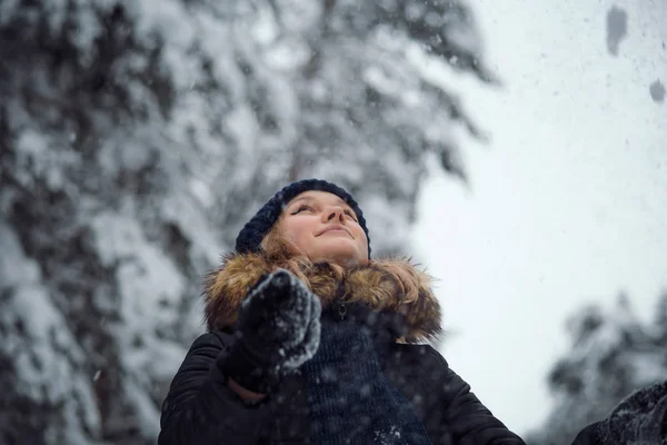 Счастливая молодая женщина играет со снегом — стоковое фото