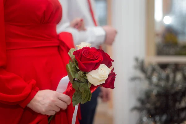 Ślub: narzeczeni wyjść za mąż, w rękach panny młodej bukiet czerwonych i białych róż — Zdjęcie stockowe