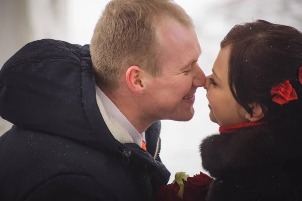 Η αγάπη ζευγάρι, ο γαμπρός και η νύφη, φιλί στο δρόμο το χειμώνα — Φωτογραφία Αρχείου