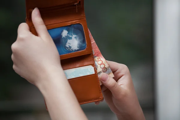 Коричневый бумажник на руке женщины — стоковое фото