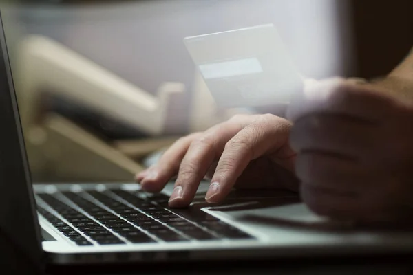 Mãos com cartão de crédito e usando laptop Fotos De Bancos De Imagens