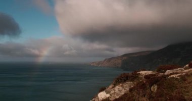 Atlantik Okyanusu Slieve Ligi uçurumlarının fırtınalı havada hareket eden bulutlar ve gölgelerle geçen destansı 4K Zaman hızlandırılmış videosu