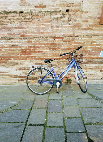 Vintage bike for picnic stands near the brick wall of Italian city.