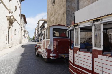 Kırmızı tren eski İtalyan şehrin sokaklarında yürürken. yürüyüş ve Turizm.