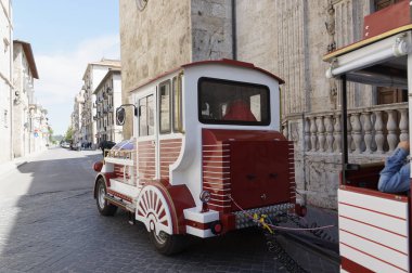 Kırmızı tren eski İtalyan şehrin sokaklarında yürürken. yürüyüş ve Turizm.