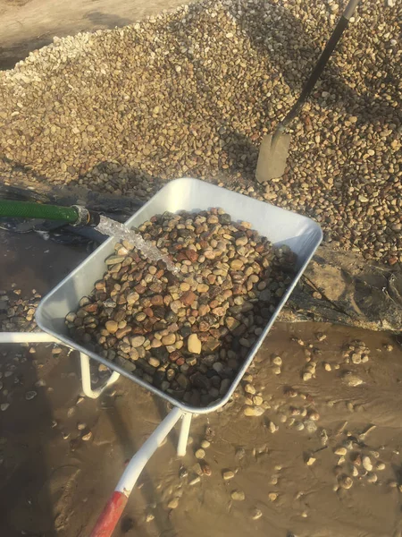 Lavagem de cascalho sob uma corrente de água — Fotografia de Stock