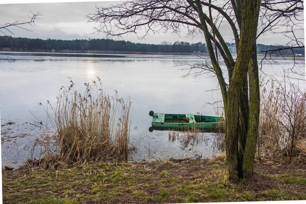 Velho, verde, barco submerso na água na margem da lagoa — Fotografia de Stock