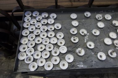 Bir grup sönmüş, bir kilisede yakılmış adak mumları. Kilisede, belirlenmiş bir yerde, teneke bir yüzey üzerinde dua mumları..