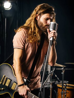 Genç adam şarkı ve Sahne Alanı'nda elektro gitar çalmak