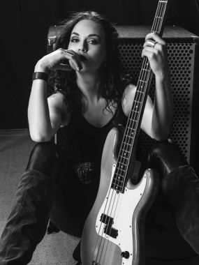Onun gitar ile oturan güzel bas gitarist