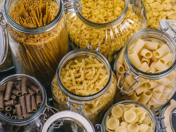 Different pasta in large glass jars — Stock Photo, Image