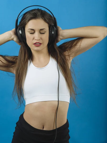 Hermosa mujer escuchando música con auriculares — Foto de Stock