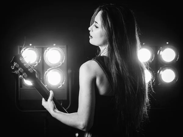 Mujer joven tocando la guitarra eléctrica en el escenario — Foto de Stock