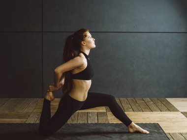 Fotoğraf güzel bir genç kadının diz çökmüş bir dörtlü yapmaya germek.