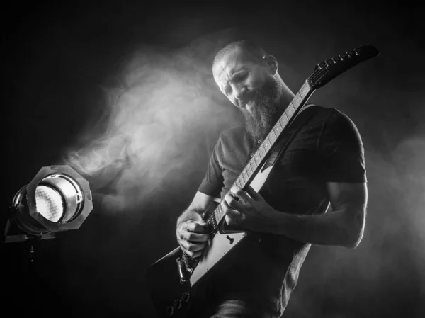 Homme barbu jouant de la guitare avec projecteur — Photo