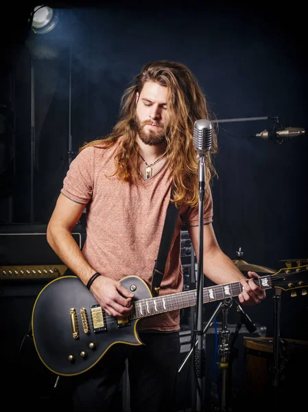 Young man playing electric guitar on stage — Stock Photo, Image