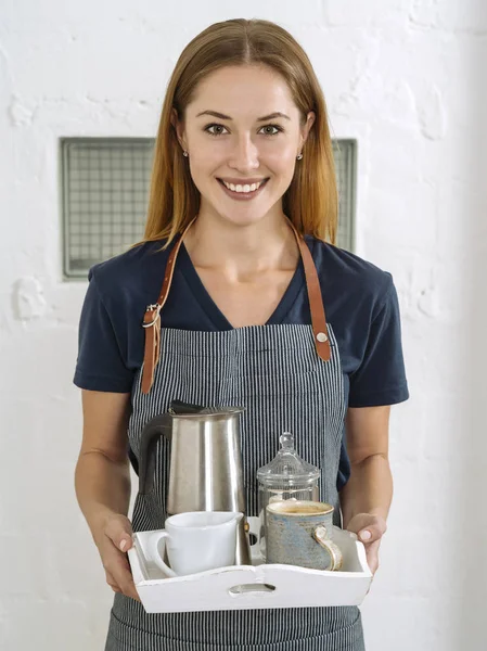 Krásná mladá žena servíruje kávu — Stock fotografie