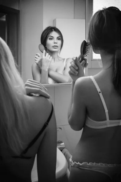 Deux femmes se brossant les cheveux dans le miroir — Photo