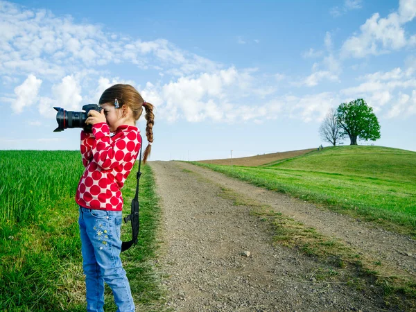 スイスの農村部で大きなカメラを持つ若い女の子が風景の写真を撮る — ストック写真
