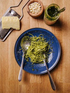 Eski ahşap bir masada fesleğen sosu ve makarna.. 