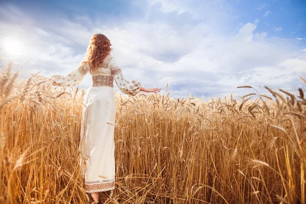 Mujer bonita vestida con blusa bordada en campo de trigo — Foto de Stock