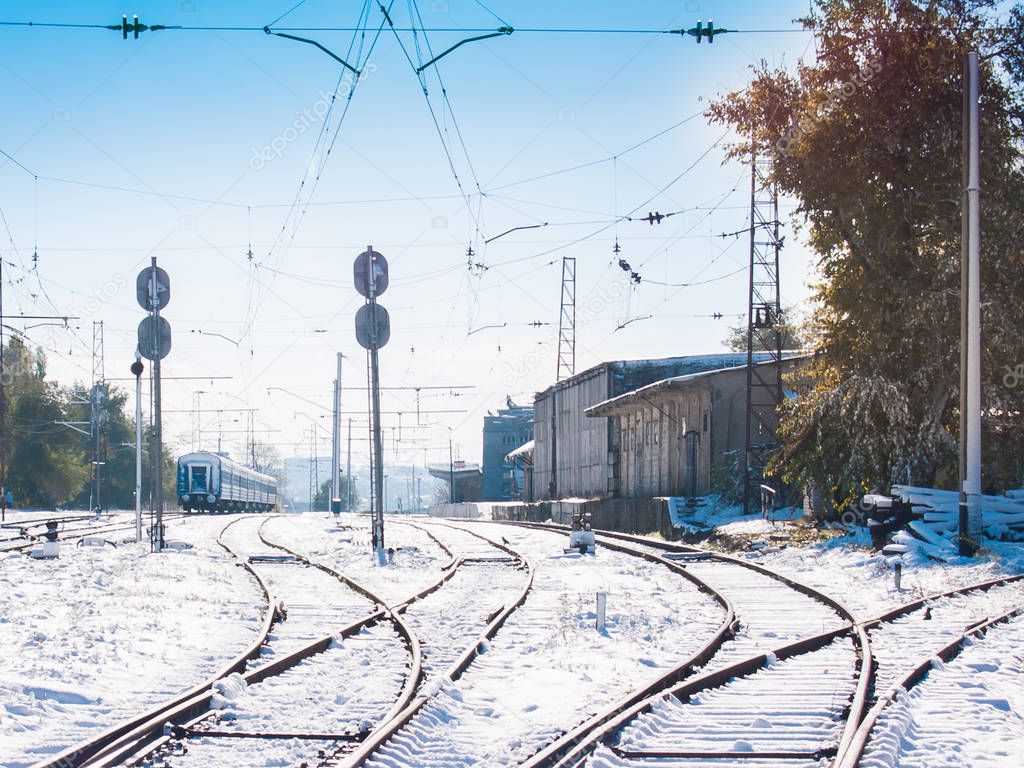 Railroad tracks running to the small snowbound station. Winter s