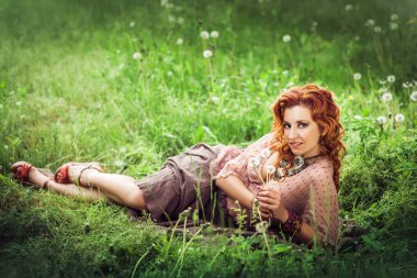 Bahar çiçeği ağacının altında güzel kızıl saçlı kadın