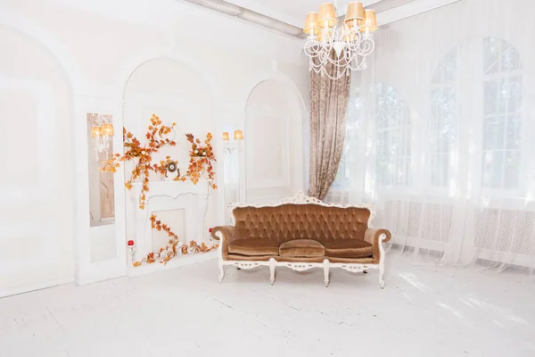 Vintage sofa in big white hall with columns, arches, classical c