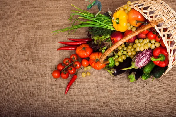 Bio zelenina, ovoce a salát v proutěném koši v koute — Stock fotografie