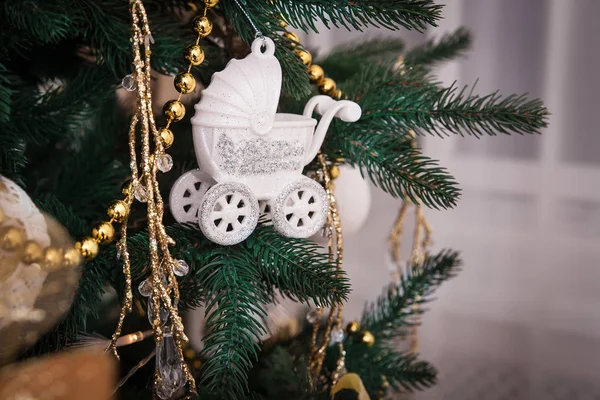 Christmas ornament pram, and other baubles on the tree. — Stock Photo, Image