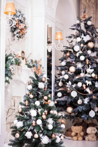 Két díszített karácsonyfa, a koszorú és a klasszikus kandalló. — Stock Fotó