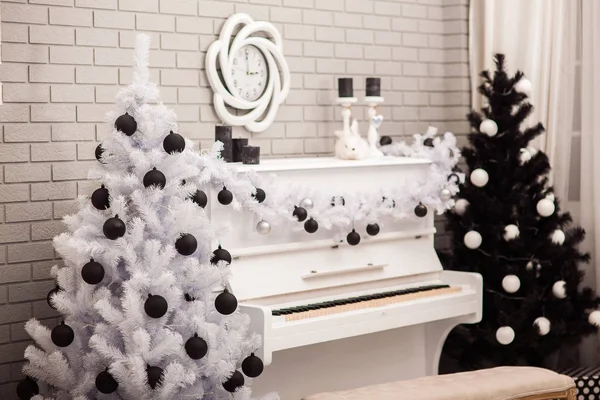 Schwarz-weißer Weihnachtsbaum neben weißem Piano — Stockfoto