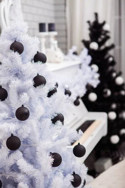 Alberi di Natale in bianco e nero vicino al pianoforte bianco. Primo piano . — Foto Stock