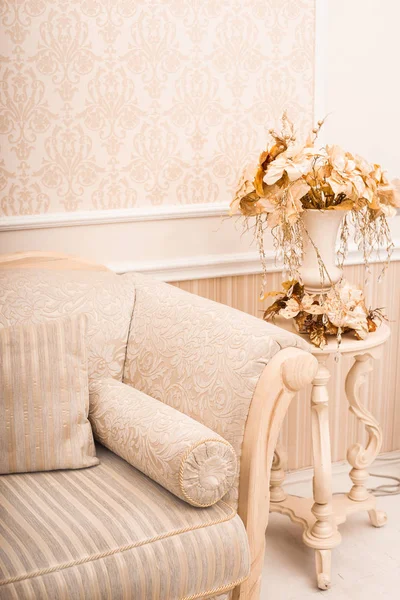 White classical sofa close-up and vase with golden branches and Stock Image