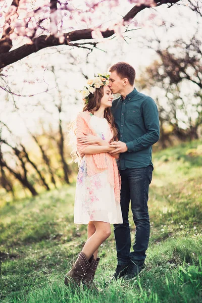 Pembe çiçeği ağaçların altında bir tarih olan aşık genç Çift. — Stok fotoğraf