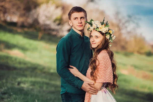 Beyaz genç kız erkek arkadaşıyla sarılma çiçek çelenk içinde — Stok fotoğraf