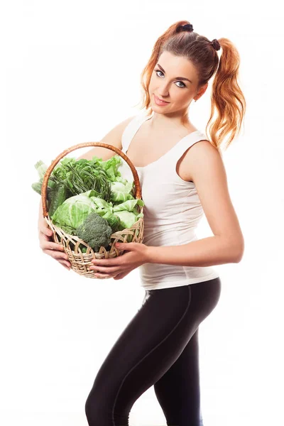 Bezaubernde schlanke Mädchen hält Korb mit frischem rohem grünen Gemüse auf weißem Hintergrund — Stockfoto