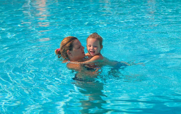 Anne kızına yüzmeyi öğretiyor.