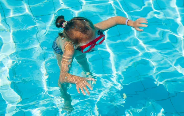 Küçük kız su altında yüzmeyi öğrenir