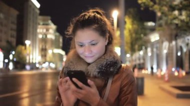 Mutlu kız yürüyor ve hareket eden Smartphone kullanır