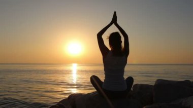 Kadın sabah sahil üzerinde meditasyon.